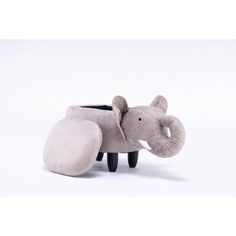 an elephant shaped planter sitting on top of a white floor next to a stuffed animal