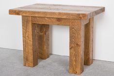 a small wooden table sitting on top of a carpeted floor next to a white wall