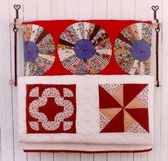 two red and white quilts hanging on a wall