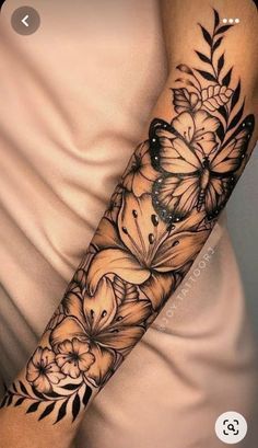 a woman's arm with flowers and butterflies on it