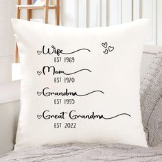 a white pillow with black lettering on it sitting on a couch next to a chair