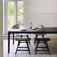 a dining room table with four chairs in front of it and an open window to the outside