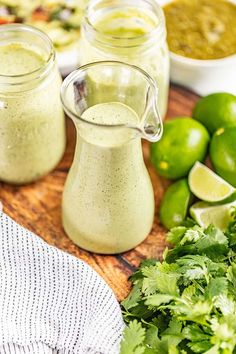 there are some limes and cilantro next to the dressing in small jars