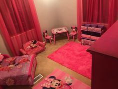 a bedroom with minnie mouse bedding and pink furniture