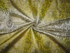 an image of a yellow and white fabric with floral designs on it's side