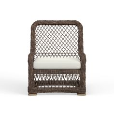 a brown wicker chair with white cushions