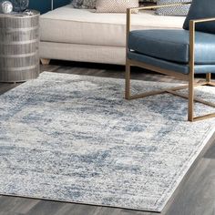 a blue and white rug in a living room next to a couch with pillows on it