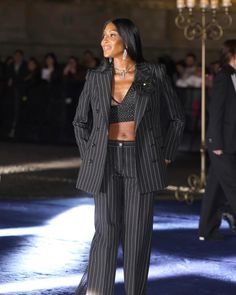 a model walks down the runway in a black and white striped suit with matching heels