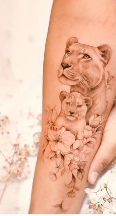 a woman's arm with a lion and flower tattoo on it