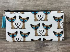 the siamese cat print zippered pouch is shown with blue eyes and black ears