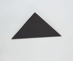 a triangle shaped object sitting on top of a white surface