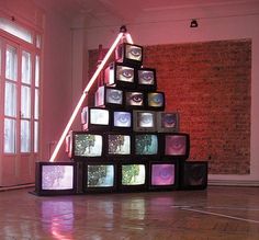 a large stack of televisions sitting on top of a hard wood floor