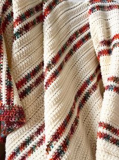 a crocheted blanket laying on top of a wooden table