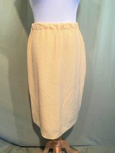 This is a lovely vintage skirt, from the 1970s. Labeled "Talbott".  No size tag, waist measures 26" to 32", please see measurements.  Made of a textured butter yellow stretch polyester knit.  It is a stretch knit with a nylon lining. Straight & knee length. It has an elastic waist band. The skirt is in good condition. No soil or stains.  No holes or tears. I don't see any moth nibbles.  Lovely! Measurements were taken with the garment lying flat. If you have never worn vintage before, please measure yourself!! Vintage sizes run smaller than today's sizes, you need to know your measurements!  Will fit best if your measurements are a little smaller than the measurements given. If you have any questions about measuring, please ask before purchasing. Waist measured from side seam to side seam: Vintage Fitted Solid Skirt, Vintage Fitted Solid Color Skirt, Vintage Pencil Skirt For Spring, Vintage Solid Color Lined Skirt, Vintage Lined Pencil Skirt For Spring, Vintage Style Lined Beige Skirt, Vintage Knee-length Pencil Skirt For Spring, Vintage Long Beige Skirt, Retro Beige Lined Skirt