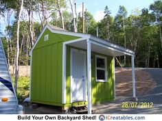 a small green and white shed next to a trailer