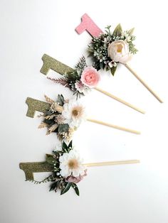 flowers are arranged in the shape of an arrow on top of toothpicks with pink and white flowers