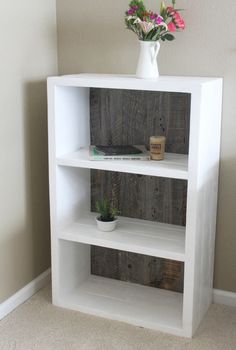 a white book shelf with flowers on top