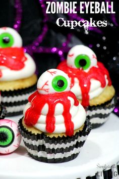 some cupcakes with fake eyes and blood on them are sitting on a plate