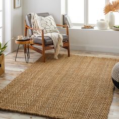 a living room area with a chair, rug and potted plants on the floor