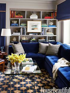 a living room filled with blue couches and a coffee table in front of a window