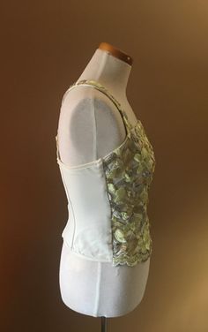 "Beautiful and unusual camisole accented with metallic floral appliqués. The top is made of nylon and Lycra for a slimming effect. Staves are added for a mild support and to maintain a slimming look. Top can be worn with jeans as well as slacks or skirt. Measures 16\" from armpit to armpit 10.5\" from armpit to hem 13\" across the waist This top has a lot of stretch!" Spring Evening Tank Top With Built-in Bra, Sequin Spaghetti Strap Camisole For Spring, Spring Sequined Spaghetti Strap Camisole, Spring Camisole With Sequins And Spaghetti Straps, Fitted Sequin Camisole, Spring Stretch Corset With Boned Bodice, Sequin Sleeveless Fitted Bodice Corset, Fitted Embellished Camisole, Embellished Fitted Camisole