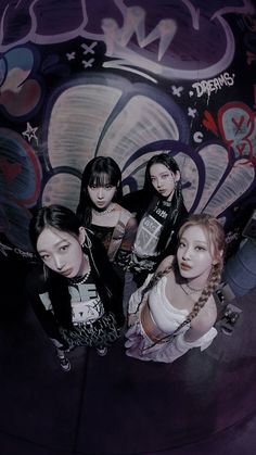 four girls standing in front of a wall with graffiti on it and one girl has her hair pulled back