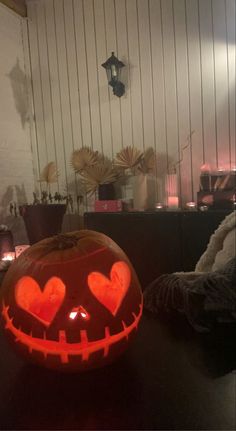 a pumpkin with hearts carved into it sitting on a table