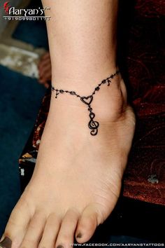 a woman's foot with a music note and heart tattoo on the side of her ankle