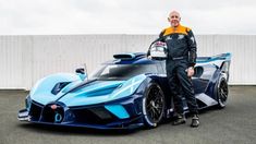 a man standing next to a blue sports car