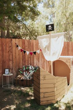 a pirate ship made out of pallets in the yard with flags and decorations around it