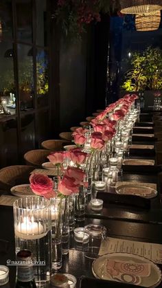 a long table is set with candles and flowers in vases on the tables are empty