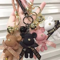 a person holding several different key chains in their hands with teddy bears attached to them