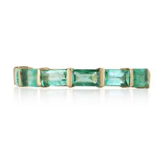 an emerald green tourmaline ring with gold accents on the sides and four rectangular cut stones