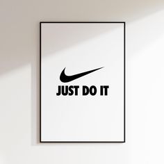 a black and white poster with the words just do it on it in front of a wall