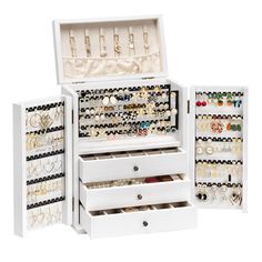 an open white jewelry box filled with lots of earrings