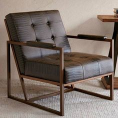 a chair sitting in front of a table with a tray on it's side