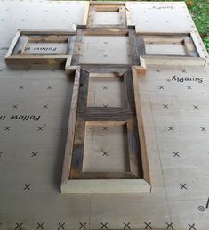 an unfinished wooden cross sitting on top of a table