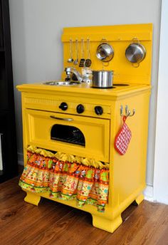 an old fashioned yellow stove with pots and pans on it