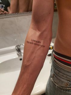 a man with a tattoo on his arm saying live a life you will never forget before