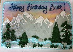 a birthday cake that is decorated with mountains and trees in the background, says happy birthday brut