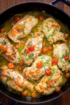 chicken with tomatoes and parsley in a skillet on a wooden countertop, ready to be eaten