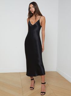 Our prettiest slip dress is here, offered in pure silk charmeuse. The Seridie mid-length dress features a deep V-neck and a subtly-sexy bias cut that clings to the figure before draping straight to a below-calf hem. With no closures for easy, effortless wear, she also includes adjustable straps so you can customize the fit. Pair with a strappy sandal for the perfect special occasion look. | L'AGENCE Seridie Silk Slip Dress In Black Affordable Midi-length Slip Dress For Night Out, Black Silk Midi Slip Dress, Reformation Black Slip Dress, Black Silk Cocktail Dress, Black Silky Dress Midi, Black Slip Dress Outfit Formal, Black Slip Dress Outfit, Black Strappy Dress, Slip Dress Outfit