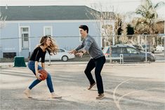 a man and woman playing basketball in the street