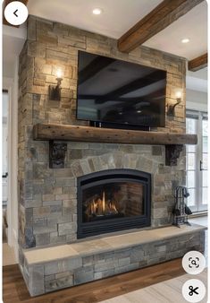 a stone fireplace with a flat screen tv mounted on it's wall above the fire place