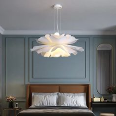 a bedroom with a bed, mirror and lamp hanging from it's ceiling over the headboard