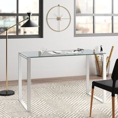 a glass desk with a clock on the wall behind it