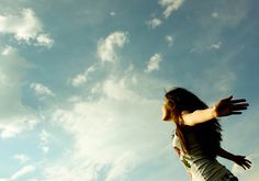 a woman flying through the air while holding her arms out in front of an advertisement