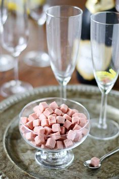 there are two wine glasses on the table with marshmallows in the bowl