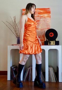 This unique shiny orange mini dress is fun and flirty for any occasion. It's a halter mini dress, with a gathered comfy bodice and bouncy bubble mini skirt. Mint condition.  Bust: 36' Waist: 29' Hip: 40' Length: 40' Fitted Flirty Orange Mini Dress, Orange Ruffled Mini Dress, Retro Spaghetti Strap Party Dress, Summer Satin Mini Dress For Costume Party, Orange Mini Dress With Spaghetti Straps For Parties, Satin Mini Dress For Summer Costume Party, Orange Ruffled Mini Dress For Cocktail, Flirty Ruched Orange Dress, Flirty Orange Ruched Dress