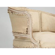 an old white chair with peeling paint on the armrests and seat cushion is shown